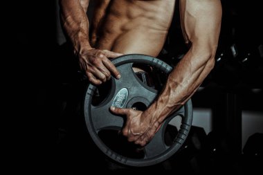 adam içinde jimnastik salonu. Halter alıştırmalar yapan kaslı vücut geliştirmeci adam. Güçlü kişi damarlar barbell ile gergin erkek el ile. Modern günlük tonlama