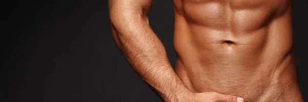 Sexy primer plano retrato de guapo modelo masculino en topless con hermosos ojos. Hombre sexy o macho muscular, culturista, con torso muscular, cuerpo con seis paquetes y abdominales posa sobre fondo negro 16 en 9 cosecha — Foto de Stock