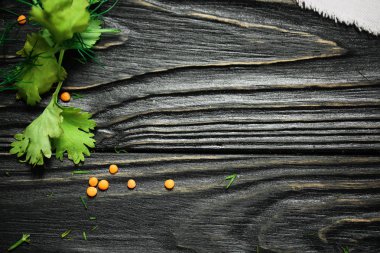 siyah ahşap arka plan. Yazı tahtası. Doku. Yeşil ve kabuğu çıkarılmış tane ve beyaz keten kumaş yukarıdan. Metin ve tasarım için alan kopyalayın. Üstten Görünüm ahşap yemek için.