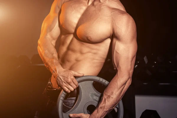 Ο άνθρωπος στο γυμναστήριο. Μυϊκή bodybuilder τύπος κάνει ασκήσεις με barbell. Ισχυρό πρόσωπο με τεταμένη αρσενική χέρι με φλέβες barbell. Σύγχρονη εφημερίδα τόνωση. Φωτοβολίδα για κείμενο και του σχεδιασμού. — Φωτογραφία Αρχείου
