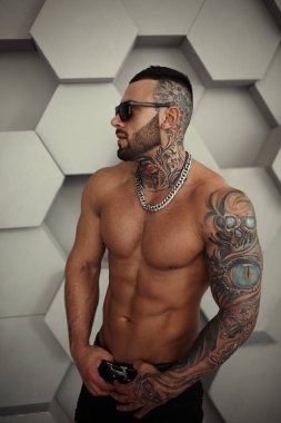 Seksi closeup moda dövme ve ayakta ve testler için veya günlüğe trend moda giysiler içinde poz siyah sakalı ile şık yakışıklı bir erkek model üstsüz portresi. Profesyonel Studio resim.