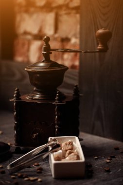 bir fincan kahve kahve dükkanı vintage renkli. Kahve Öğütücü ve kahverengi şeker kamışı parlama ile ahşap masa üzerinde arka plan bulanık. Retro tarzı