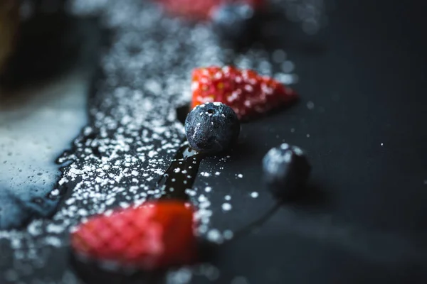 Macro foto di fragole e mirtilli su lastra di ardesia con sfondo cocco. Concetto di cibo. Frutta rossa estiva. Oggetto di chiusura. Spazio copia bagliore per testo, design — Foto Stock