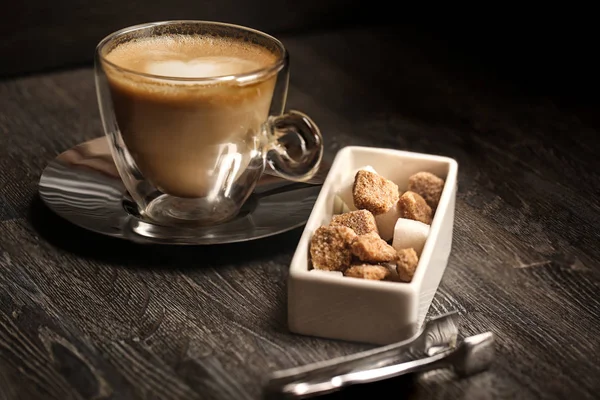 bir fincan kahve kahve dükkanı vintage renkli. Kahve Öğütücü ve kahverengi şeker kamışı parlama ile ahşap masa üzerinde arka plan bulanık. Retro tarzı