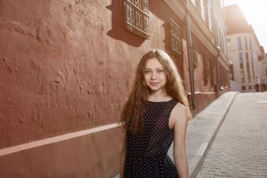 Elbise ve sokakta yürüyen güzel esmer genç kadın. Metin ve tasarım için işaret fişeği. Şehirde yaşam tarzı.