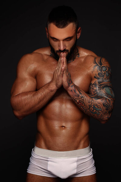 Сексуальный крупным планом портрет красивой топлесс мужской модели с красивыми глазами. Сексуальный мужчина или мускулистый мачо, бодибилдер, с мышечным туловищем, тело с шестью пачками и прессом позирует на черном фоне в белом
