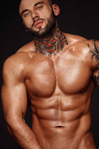 Sexy closeup portrait of handsome topless male model with beautiful eyes. Sexy man or muscular macho, bodybuilder, with muscle torso, body with six packs and abs poses on black background in white
