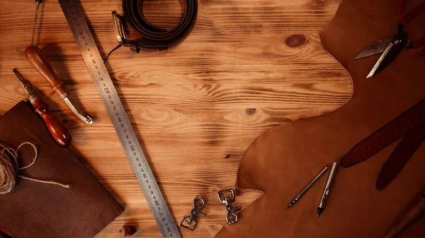 Lederhandwerk. Gerber-Werkzeuge auf grauem Holzhintergrund von oben. Kopierraum — Stockfoto