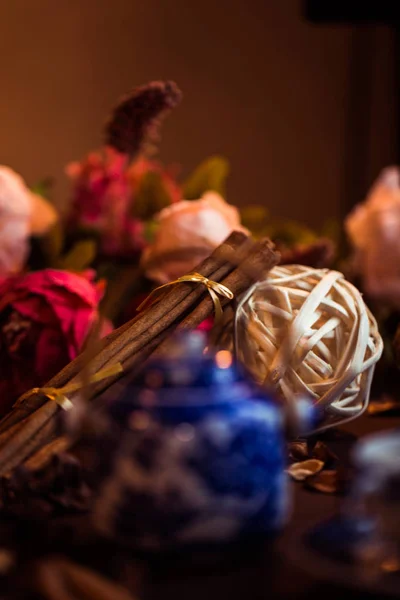 Cannelle moulue, bâtonnets de cannelle, reliés à un plateau avec un arc sur un fond floral dans un style rustique. Concentration sélective. Concept de nourriture. Soin vintage. Style rétro — Photo