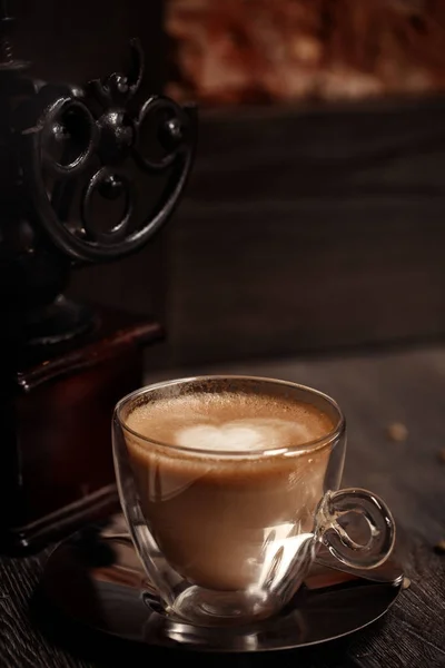 Чашка кофе винтажного цвета в кофейне. Кофемолка и коричневый тростниковый сахар на деревянном столе с размытым фоном. Ретро стиль — стоковое фото