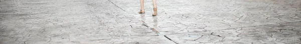 Woman is going on the street. Legs crop. Texture of the old road with cracks. Asphalt surface on the street. Web banner size — Stock Photo, Image