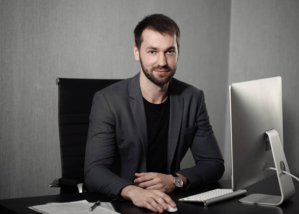 Умный бизнесмен на рабочем месте в офисе держит голову на руках. Сонный работник рано утром после поздней ночной работы. Концепция Биснансе и финансов
.