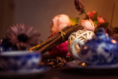 Tarçın, tarçın çubukları zemin, rustik tarzda çiçek bir arka plan üzerinde bir yay ile bir tepsi ile bağlı. Seçici odak. Gıda kavramı. Vintage tonlama. Retro tarzı