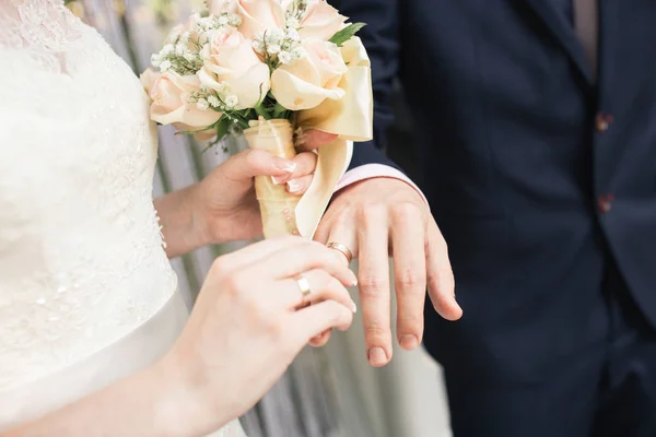 梨花の手に大きな素敵なウェディング ブーケ。花嫁は、新郎の指にリングを入れる — ストック写真
