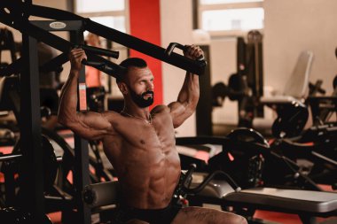 Spor tema adam. Sporcu spor salonunda çalışma dışarı. Kaslı vücut egzersizleri yapıyor