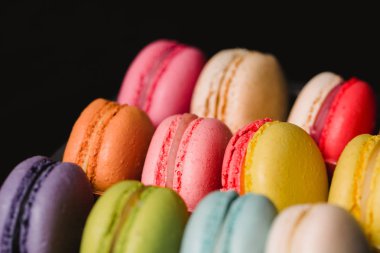 Renkli macaroons siyah arka plan üzerinde ayarlayın. Closeup gıda fotoğraf