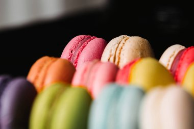 Renkli macaroons siyah arka plan üzerinde ayarlayın. Closeup gıda fotoğraf
