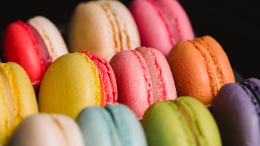 Renkli macaroons siyah arka plan üzerinde ayarlayın. Closeup gıda fotoğraf