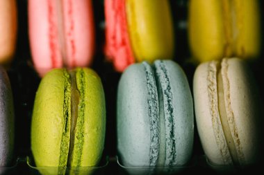 Renkli macaroons siyah arka plan üzerinde ayarlayın. Closeup gıda fotoğraf. Makro fotoğrafçılık