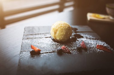 Izgara-dondurmanın içine Hindistan cevizi soslu siyah taş plaka üzerinde. Asya gıda arka plan. Beslenme kavramı. Ahşap masa ile restoran yer. Metin, tasarım için kopya yer flare. 16 9 ürün