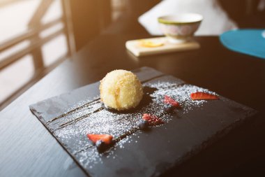 Izgara-dondurmanın içine Hindistan cevizi soslu siyah taş plaka üzerinde. Asya gıda arka plan. Beslenme kavramı. Ahşap masa ile restoran yer. Metin, tasarım için kopya yer flare. 16 9 ürün