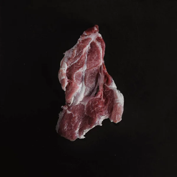 乡村风格的食物照片。生肉。猪肉牛排在黑色背景石板板。顶部视图。平躺 — 图库照片