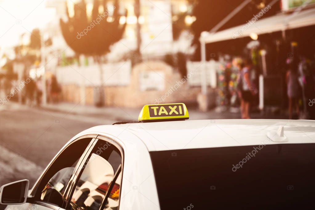 Yellow taxi sign. Taxi car on the street in city. Orange yellow warm toning bokeh background