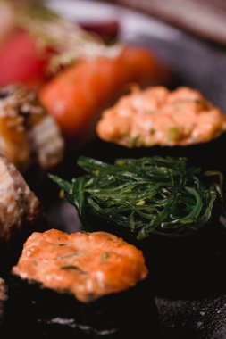 Closeup suşi nigiri ve rulo kahverengi ahşap masa tabakta servis. Sağlıklı Asya gıda. Makro fotoğrafçılık