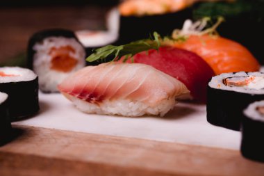 Closeup suşi nigiri ve rulo kahverengi ahşap masa tabakta servis. Sağlıklı Asya gıda. Makro fotoğrafçılık