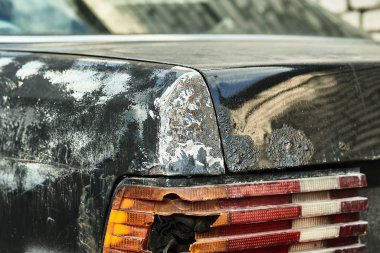 Eski arabanın detayları. Yıllanmış eski model bir otomobil. Eski klasik otomobilin yedek parçaları. Otoparkta parçalanmış bir araba.