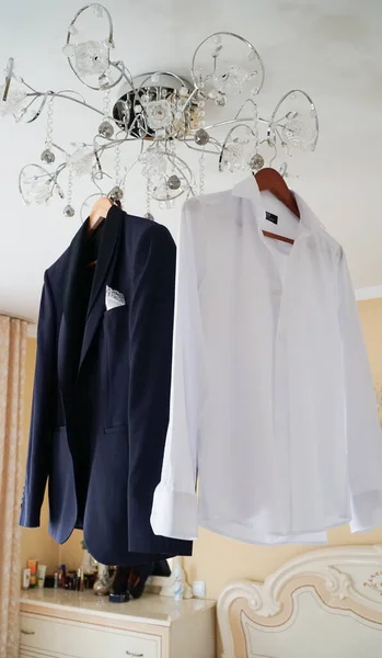 Wedding concept. Groom\'s suit hanging on a hanger at the door.