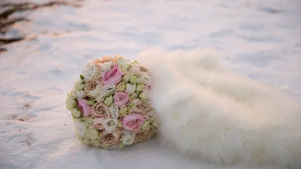 Düğün günü ve buketi dağların arka planında karda..