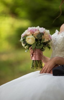 Bir buket çiçeğin ellerinde.