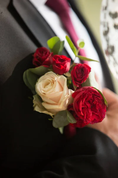 Gelin, damadın ceketindeki çiçekleri düzeltir..