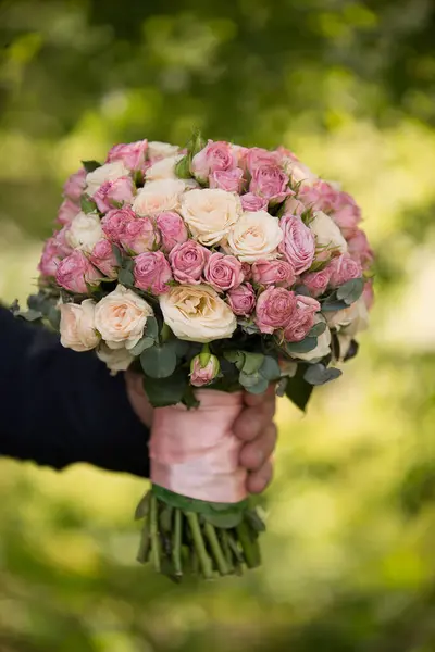 Genç bir kızın ellerinde düğün çiçekleri.