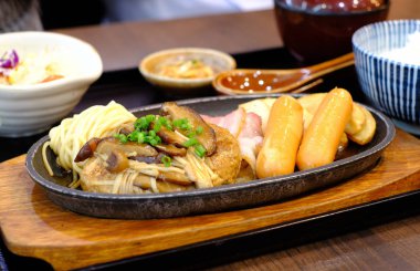 Hamburg bifteği, sosis, pirinç ve salata.