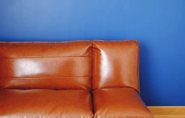 brown leather sofa with blue background
