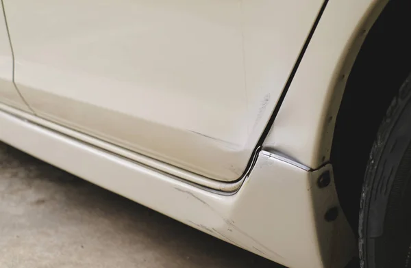 Beyaz arabanın arka tarafında çizikler var.