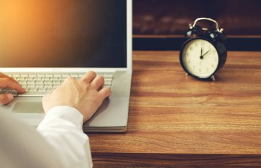 İşadamı bilgisayarında çalışıyor. Siyah çan saati geçmişi var.