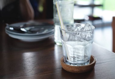 Bardaktaki buzlu su ahşap masaya konur.