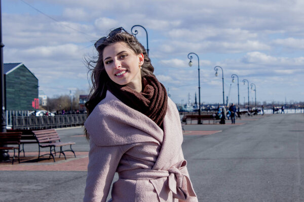 Beautiful young dark-haired girl on the waterfront