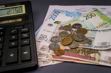 Bir hesap makinesi ve değişiklik karanlık bir arka plan üzerinde banknot.