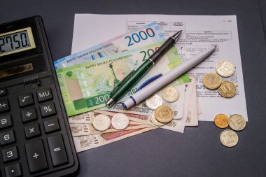 Bir hesap makinesi ve değişiklik karanlık bir arka plan üzerinde banknot. 