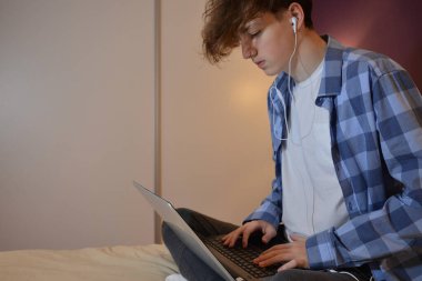 Evde dizüstü bilgisayarı olan genç bir adam.