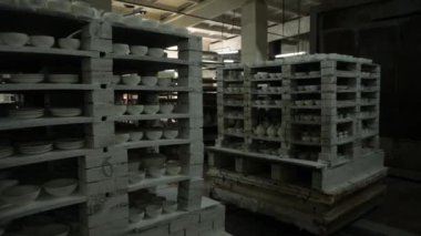 Mutfak malzemeleri dükkânı. Fırında toprak eşyasıyla birlikte iki mobil raf. Dairesel panorama. Genel plan. Gri Tonlama.