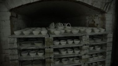 Tabakları fırlatmak için fırın. Fırından fırında pişmiş bir toprak parçası sarkıyor. Subjektif olarak. Yukarıdan manzara. Genel plan. Gri Tonlama.