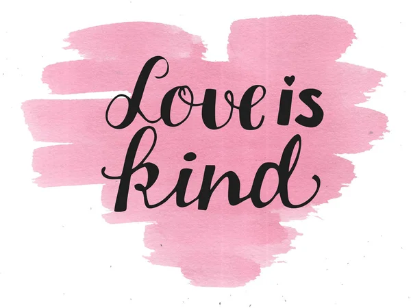 Hand lettering Love is kind made on watercolor background.