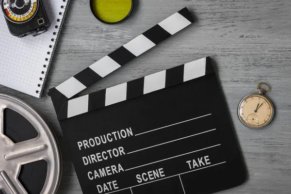Clapperboard, a roll of film and watch — Stock Photo, Image