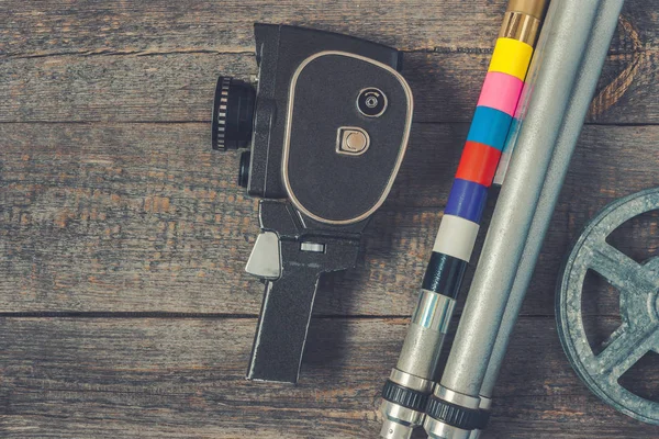 Old movie camera, tripod and film reel — Stock Photo, Image