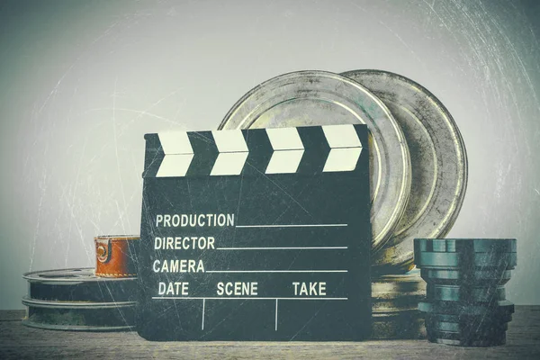 Clapperboard, tin boxes with film and lens — Stock Photo, Image